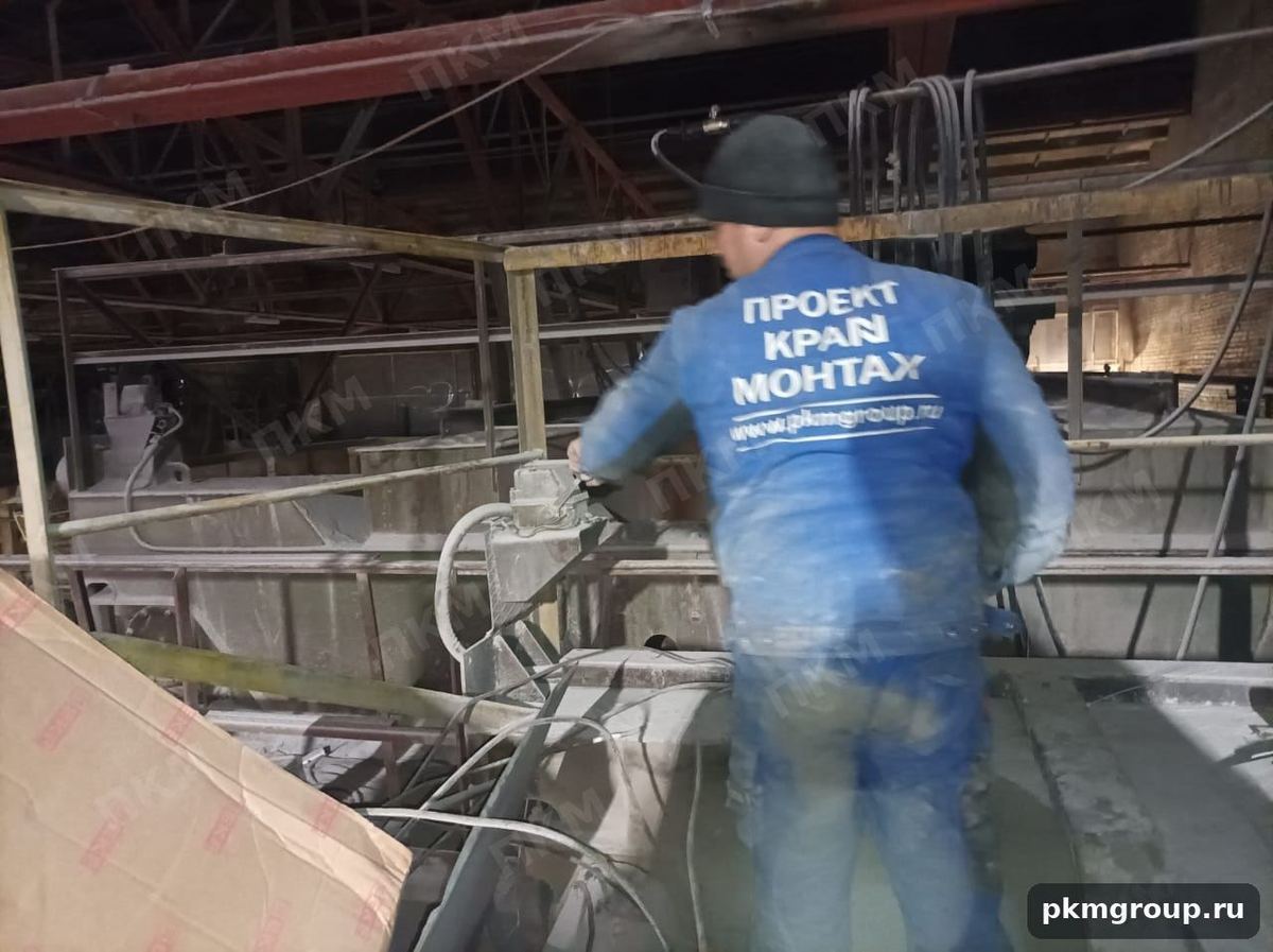 Специалист ПроектКранМонтаж на мосту крана во время работ